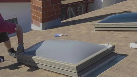 Man Taking off the Frame of a Skylight Window on a Rooftop Stock Footage 212417868