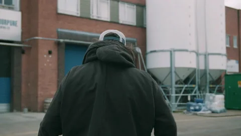 Man taking his jacket off while walking outside of brewery Video stock 131244285