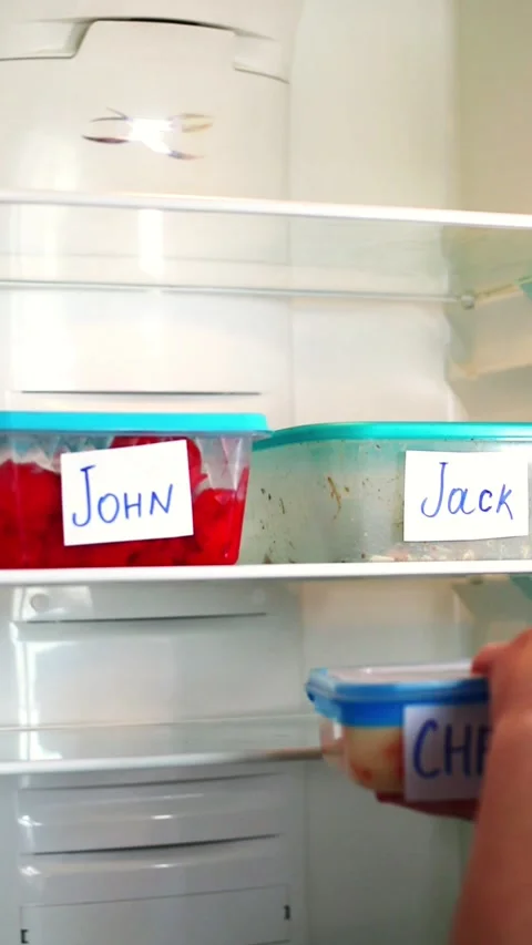 Man taking his lunchbox from fridge. Meal containers labeled with employee Stock Footage 312011690
