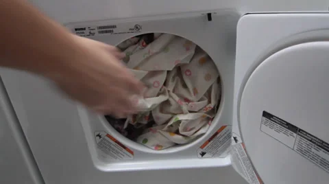 A man Taking Laundry Out of a Dryer Video stock 34480892