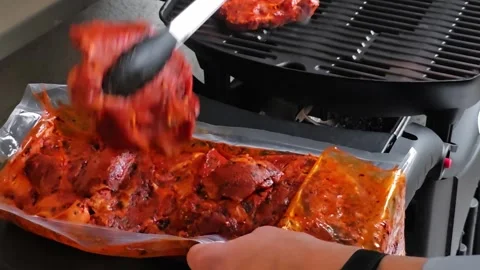 Man taking a marinated beef steak out of a plastic tray and setting it on a.. Stock-Footage 343165759