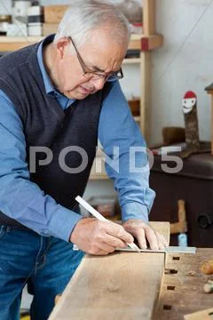 Man taking measurement using scale on wood Stock Photos