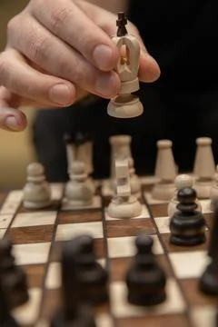 Man taking next step on chess game. Human hand moving wooden white chess king Stock Photos