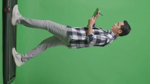 Man Taking Note On Tablet While Walking On Green Screen In The Studio Stock Footage 248007458