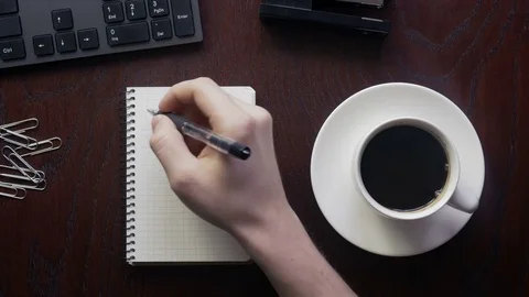 Man taking notes and drinking black coffee early in the morning Stock-Footage 73259338