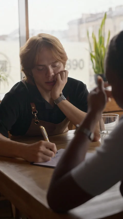 Man Taking Notes on Clipboard during Job Interview in Coffee Shop Stock Footage 344371640
