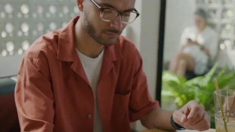 Man Taking Notes in Copybook at Cafe Table Video stock 235775879