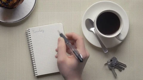 Man taking notes in his notebook near a cup of coffee Stock-Footage 75458522