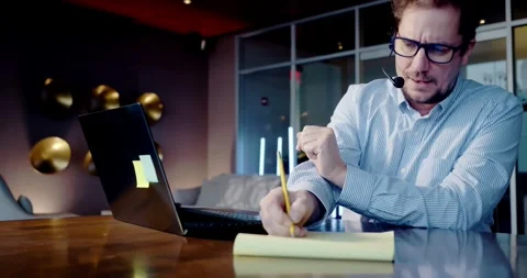 Man Taking Notes in Modern Office Environment Stock Footage 323681030