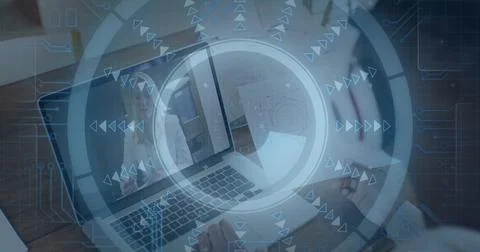Man taking notes in notebook at desk, laptop displaying meeting with interface Stock Photos