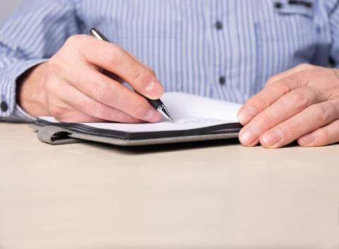 Man taking notes in planner. Hands closeup writing information, agenda Stock Photos