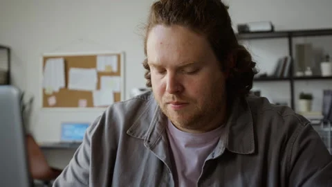 Man Taking Notes While Working on Laptop in Office Stock Footage 348139898