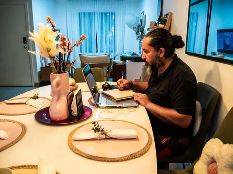 Man Taking Notes While Working Remotely Stock-Fotos