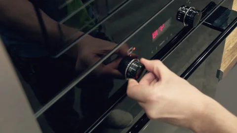Man taking out a hot baking sheet of homemade pizza from the oven, close-up Stock Footage 163564395