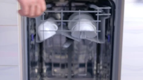 Man taking out white cups and bowls from basket of dishwasher, hands closeup. Stock Footage 116373754