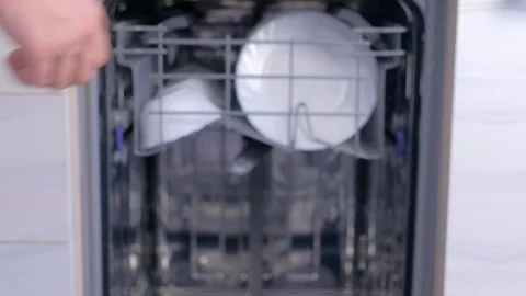 Man taking out white plates and bowls from basket of dishwasher, hands closeup. Stock Footage 116374014