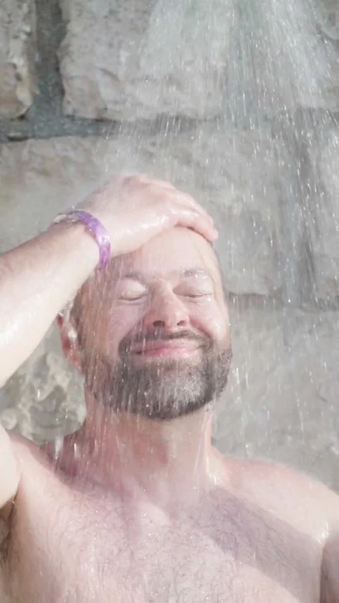 Man taking an outdoor shower on the beach Stock Footage 280319342