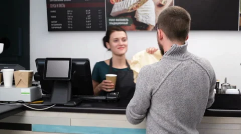 Man taking the package and cup of coffee at the fast food restaurant Stock Footage 67613697