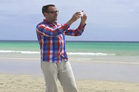Man taking photo with cellphone by the sea, super slow motion, shot at 120fps Stock Footage