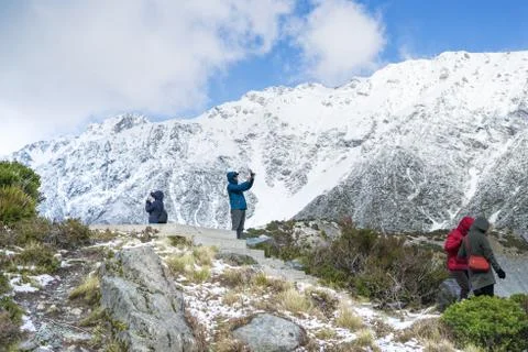 Man taking photo using smart phone on the snow mountain. Stock Photos