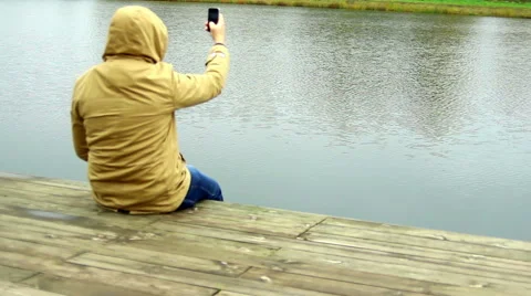 Man taking picture with camera mobile phone or smartphone. Focus on water Stock Footage 43025847