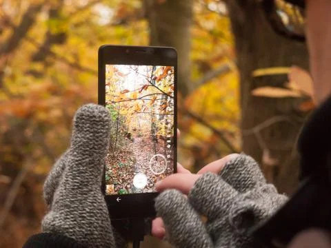 Man taking a picture with camera smart phone touch screen nature outside autu Stock Photos