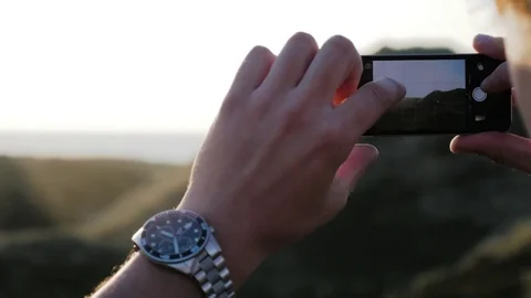 Man taking the picture of sunset on mobile phone Stock Footage 71564935