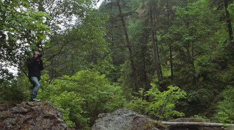 Man taking pictures on a cliff Stock Footage 44324908