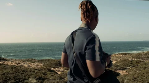 Man taking pictures of ocean Stock Footage 114002971