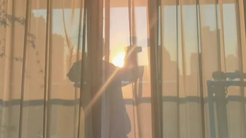 A man taking pictures,the setting sun cast his shadow on the gauze curtain. Stock Footage 170474136