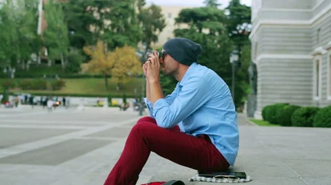 Man taking pictures by using old camera on public square Video stock 43083164