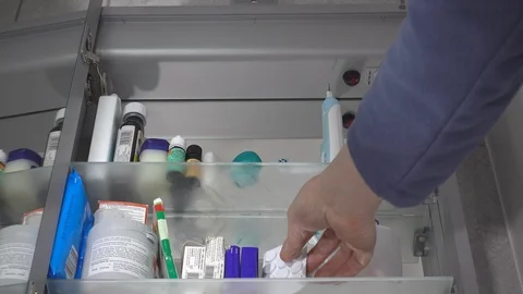 Man taking pills / tablets from a mirrored bathroom cabinet. Stock-Footage 87167137