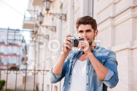 Man taking pistures with old photo camera in the city Stock Photos
