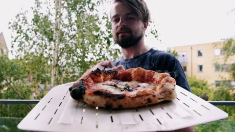 Man taking pizza from the oven Video stock 132848720