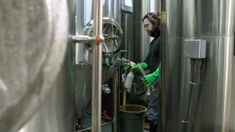Man taking a sample from a beer fermenter Stock Footage 77078993