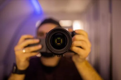 Man taking self-portrait inside an airplane bathroom Stock Photos