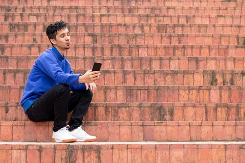 Man taking a selfie with a funny expression. Orange and blue. Man wearing a blue Foto stock