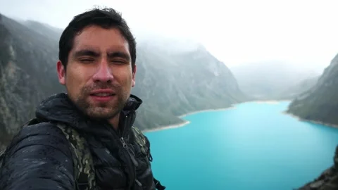 A man taking a selfie with an incredible background of a turquoise lagoon called 스톡 동영상 164541673