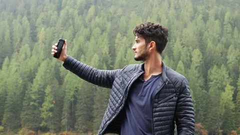 Man taking selfie at lake Stock Footage 81838703