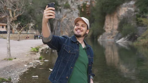 Man taking a selfie by the river Stock Footage 265120782