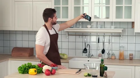 Man taking a selfie while standing in the kitchen before preparing a vegan meal Stock Footage 151393756