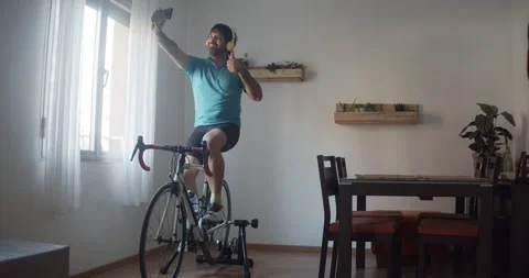 Man taking a selfie while training with his exercise bike at home. Stock Footage 145908100