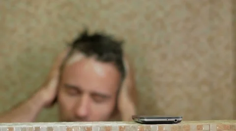 A man taking a shower at the hotel. Checks on the phone message, and continues Stock Footage 67520503