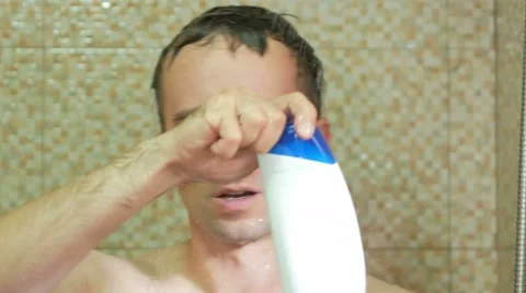 A man taking a shower at the hotel. He pours shampoo in hand, soaps head Stock Footage 67521580
