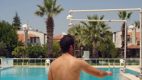 Man taking shower outside in the pool, slow motion shot at 240fps Stock Footage 97105624