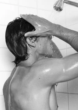 Man taking shower, side view, b&amp;w Fotos Stock
