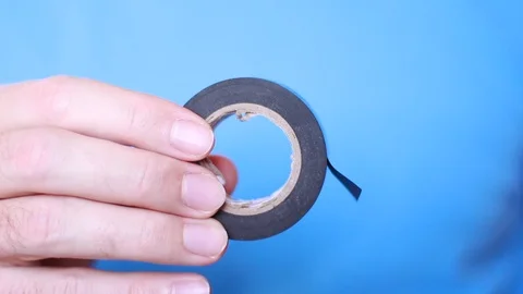 Man taking shred of black insulating tape Vídeo Stock 101676994