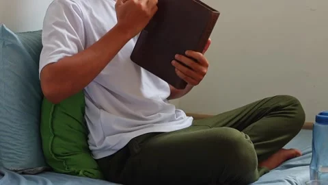 Man taking sip from glass and grabbing his notebook diary in bedroom Stock Footage 341487544