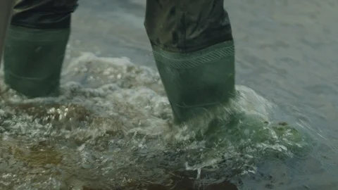 Man taking soil samples in water waders and boots with assistant - closeup Stock Footage 106419023