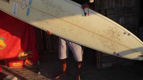 Man taking the surfboard and walking to the beach Stock Footage 148620866